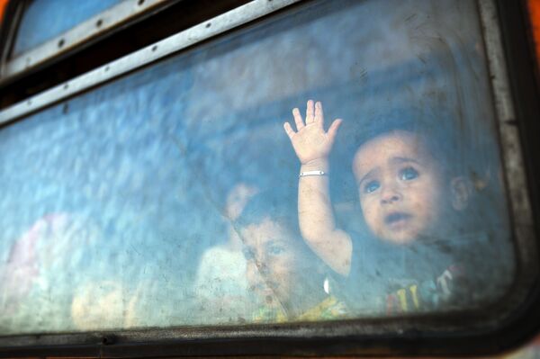 کودکان پناهجویان در اتوبوسی در مرز یونان و مقدونیه - اسپوتنیک ایران  