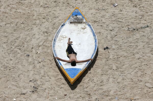 جوان فلسطینی در حال استراحت در ساحل در غزه - اسپوتنیک ایران  