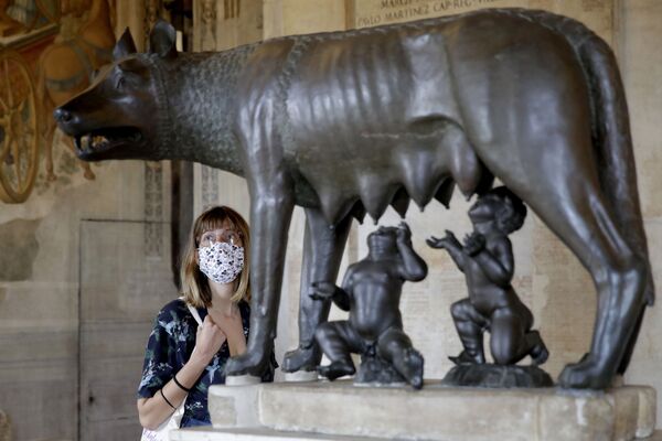 بازدید کننده ای با ماسک در حال تماشای مجسمه گرگ در موزه رم.
 - اسپوتنیک ایران  