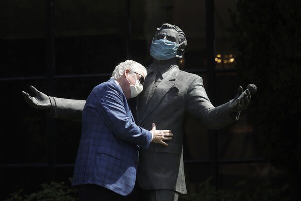 معاون ریاست منطقه ای Fairmont Hotels در حال بغل کردن مجسمه خواننده تونی بنت در کنار هتلFairmont San Francisco - اسپوتنیک ایران  