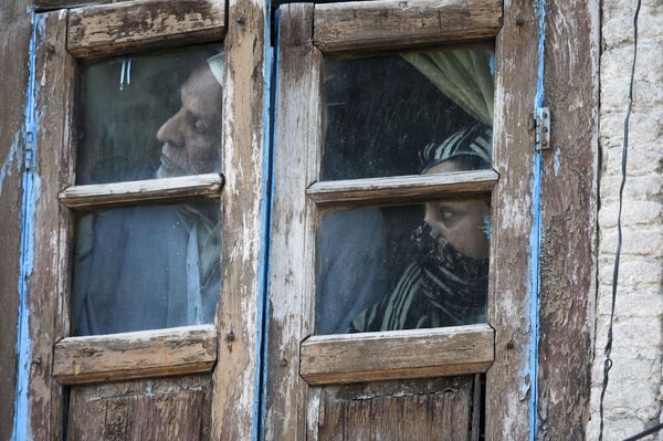 افراد خانه ای در هند از پنجره بیرون را تماشا می کنند - اسپوتنیک ایران  