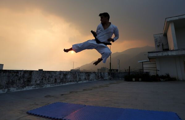 ورزشکار ونزوئلایی در حال تمرین روی بام خانه اش - اسپوتنیک ایران  