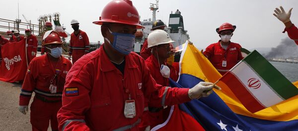 Венесуэльский работник нефтеперерабатывающего завода с флагом Ирана во время прибытия иранского танкера с топливом Венесуэльский работник нефтеперерабатывающего завода с флагом Ирана во время прибытия иранского танкера с топливом - اسپوتنیک ایران