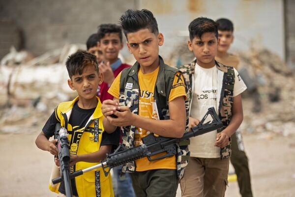 کودکان عراقی با اسلحه اسباب بازی در بصره، عراق
 - اسپوتنیک ایران  