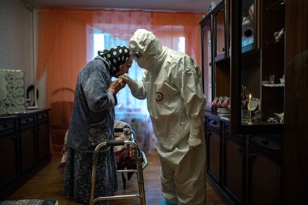 کشیشی به دیدن بیماران کووید ۱۹ که در خانه درمان می شوند، رفته است - اسپوتنیک ایران  