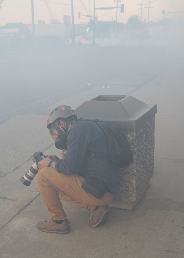 خبرنگار رویترز کاللوس باریا در زمان پرتاب گاز اشک آور در مینیاپولیس - اسپوتنیک ایران  