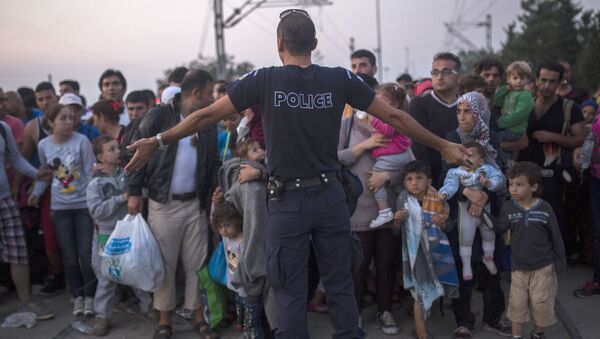 Греческий полицейский преграждает путь сирийским беженцам на границе между Грецией и Македонией - اسپوتنیک ایران  