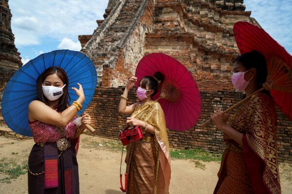 زنانبا ماسک های محافظ و لباس های سنتی در شهر تاریخی آیوتایایا، تایلند
 - اسپوتنیک ایران  