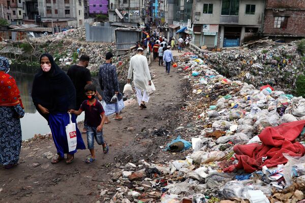 مردم در امتداد جاده ای که در میان انبوهی از زباله ها قرار دارد قدم می زنند، داکا، بنگلادش.
 - اسپوتنیک ایران  