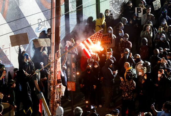 معترضان در جریان راهپیمایی سیاتل علیه نابرابری نژادی، پرچم آمریکا را می سوزانند
 - اسپوتنیک ایران  