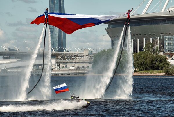 ورزشکاران تیم ملی روسیه با فلای برد پرچم کشور را در مراسم جشن روز روسیه برافراشته می کنند، سن پترزبورگ - اسپوتنیک ایران  