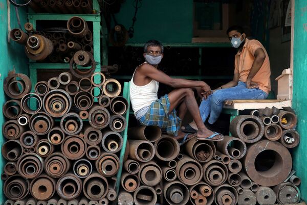 کارگران با ماسک در مغازه ی فروس لوله های فلزی در بازار کلکته هند - اسپوتنیک ایران  