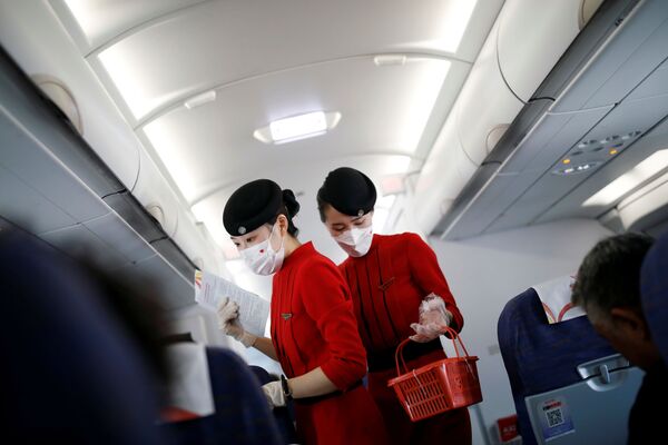 مهمانداران با ماسک در  هواپیمای شرکت هوایی سینچاون چین - اسپوتنیک ایران  