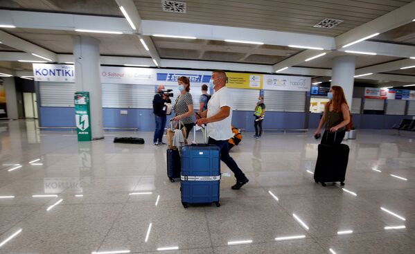 توریست های آلمانی با ماسک در فرودگاه پالما دی مایورکا در اسپانیا - اسپوتنیک ایران  