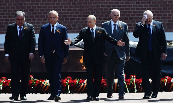 ولادیمیر پوتین، رئیس جمهورروسیه به همراه مهمانان خارجی هنگام مراسم نثار شاخه های گل به آرامگاه سرباز گمنام در مسکو  - اسپوتنیک ایران  
