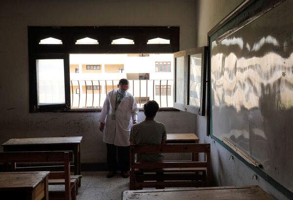 پزشک مشغول معاینه دانش آموز در روز امتحان در قاهره مصر - اسپوتنیک ایران  