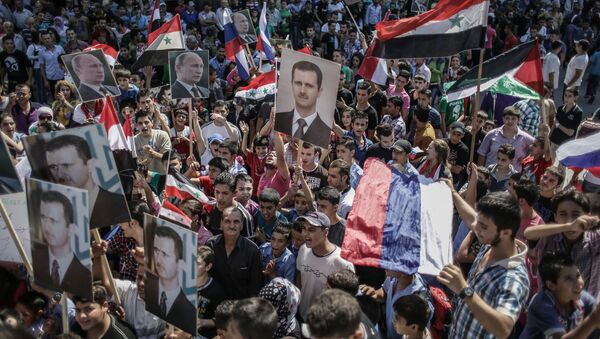 Участники митинга в поддержку президента Сирии Башара Асада и президента России Владимира Путин в Латакии, Сирия - اسپوتنیک ایران  