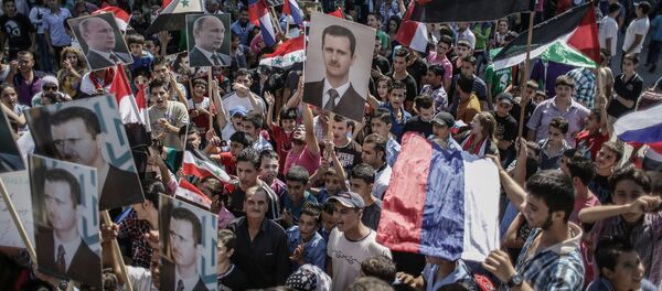 Участники митинга в поддержку президента Сирии Башара Асада и президента России Владимира Путин в Латакии, Сирия - اسپوتنیک ایران  