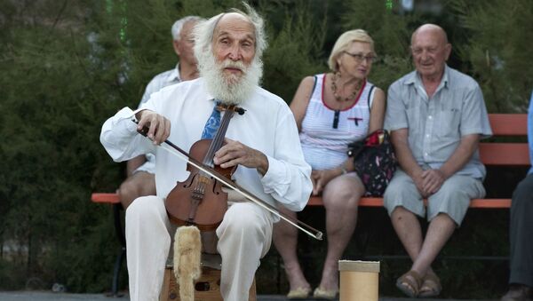 نوازنده خیابانی در حال نواختن ویلون - اسپوتنیک ایران  