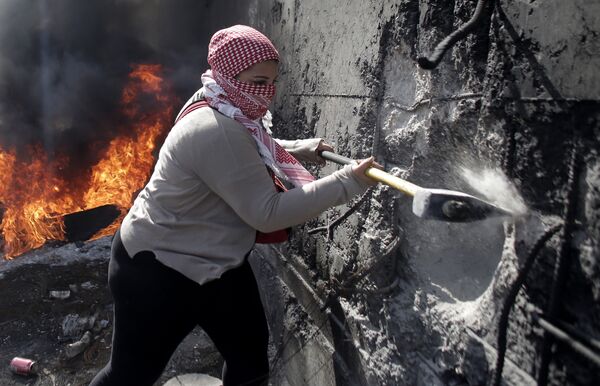 زن فلسطینی در حال ویرانی دیوار جداکننده - اسپوتنیک ایران  