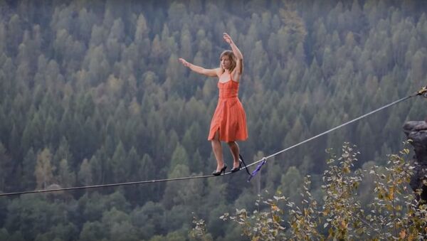 طناب بازی خانم امریکایی با کفش پاشنه بلند در ارتفاع 840 متری - اسپوتنیک ایران  