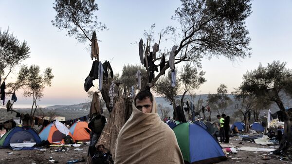 Беженец в полотенце беженец на фоне палаток на греческом острове Лесбос - اسپوتنیک ایران  