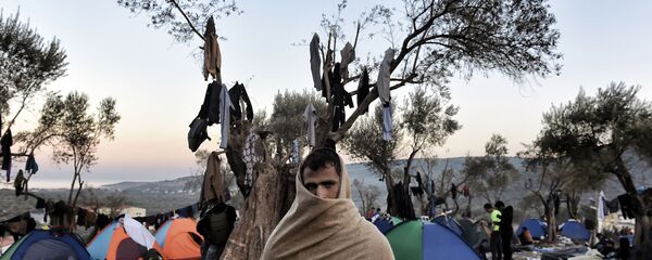 Беженец в полотенце беженец на фоне палаток на греческом острове Лесбос Беженец в полотенце беженец на фоне палаток на греческом острове Лесбос - اسپوتنیک ایران