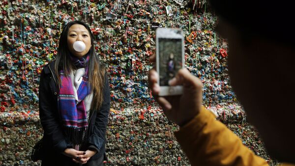 Девушка фотографируется на фоне стены жевательной резинки в Сиэтле - اسپوتنیک ایران  