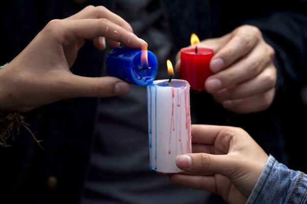 شمع های روشن شده به یاد قربانیان در مقابل سفارت فرانسه در پرو - اسپوتنیک ایران  
