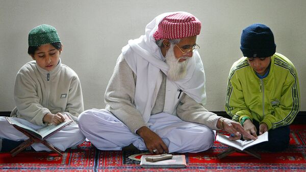An Iman helps a young boy learn The Koran at The Central Mosque in Luton - اسپوتنیک ایران  