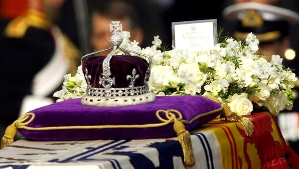 The Koh-i-noor, or mountain of light, diamond, set in the Maltese Cross at the front of the crown made for Britain's late Queen Mother Elizabeth, is seen on her coffin, along with her personal standard, a wreath and a note from her daughter, Queen Elizabeth II, as it is drawn to London's Westminster Hall in this April 5, 2002 file photo. - اسپوتنیک ایران  